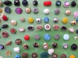 many different types of buttons on a green surface