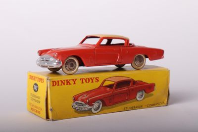 a red toy car sitting on top of a yellow box