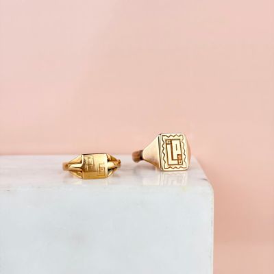 a pair of gold cuff rings on a marble block