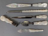 five different types of knives and spoons laid out on a table
