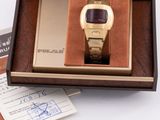 a watch in a box on a table with a note