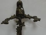 bronze statue of a bird perched on a branch of a tree