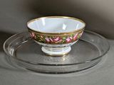 a cup and saucer sitting on a plate on a table