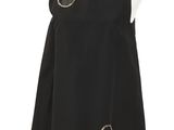 La robe est noire et ornée de cercles argentés.