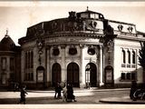une vieille photo d'un bâtiment autour duquel des gens se promènent
