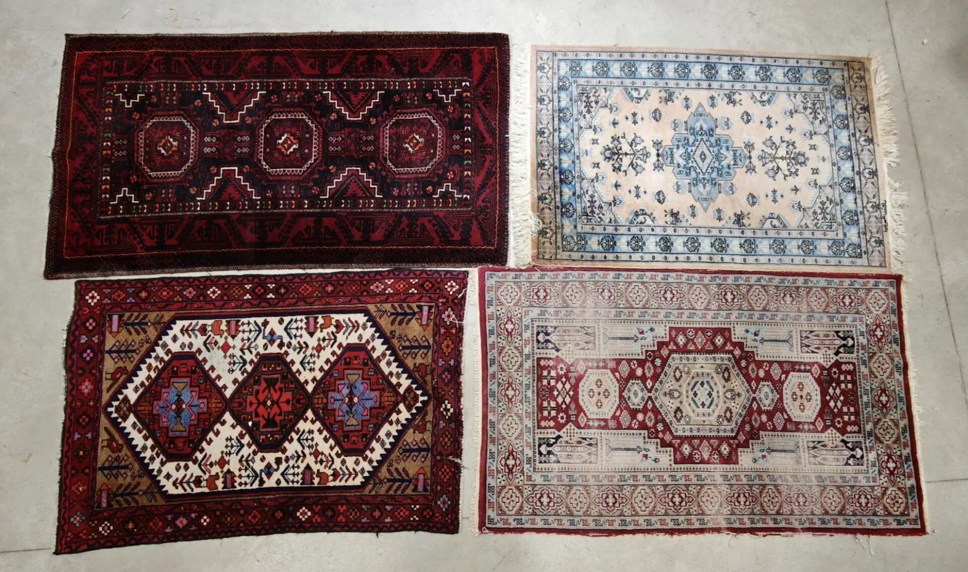 Quatre tapis en laine à motifs géométriques et floraux. Dim. max. : 180 x 100 cm (usures)