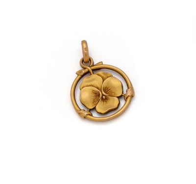 un gros plan d'un pendentif en or orné d'une fleur