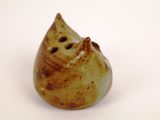 a small ceramic figurine of a cat on a white surface
