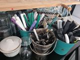 many different types of kitchen utensils in a bucket