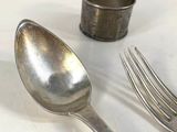 two spoons and a fork on a white table