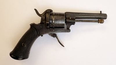 gros plan d'un revolver sur une surface blanche