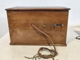 a wooden box that has a cord in it