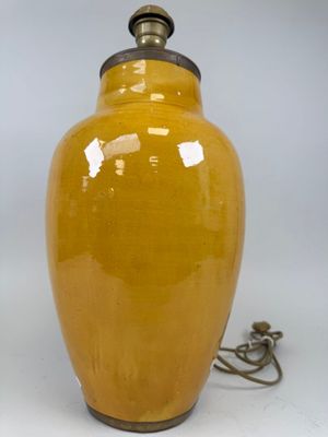 pair of yellow ceramic vases with metal handles on a white background
