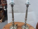 pair of silver candles sitting on top of a wooden table