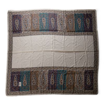 a white blanket with a blue and brown design on it
