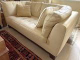 a white couch with pillows on it in a living room
