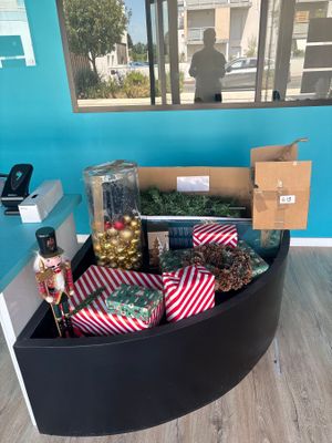 une boîte noire remplie de décorations de Noël posée par terre