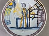 une assiette avec l'image d'une femme et d'un oiseau