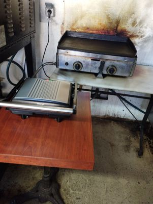 un ordinateur portable posé sur une table à côté d'un barbecue