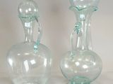 two clear glass vases sitting on a white surface