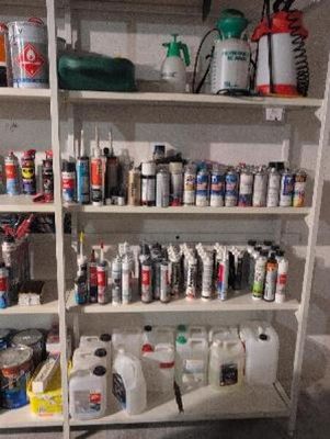 many cans of paint on the shelves in the room