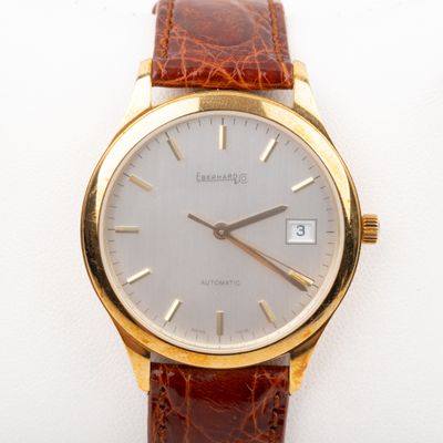 a gold wrist watch with a brown leather strap