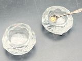 two glass bowls with a spoon in them on a table