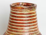 a brown and white vase sitting on a table