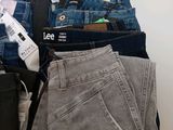 several pairs of jeans are stacked on top of each other