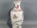 a white vase with a painting on it sitting on a table