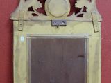 un petit miroir posé sur une table, avec un mur rouge en arrière-plan