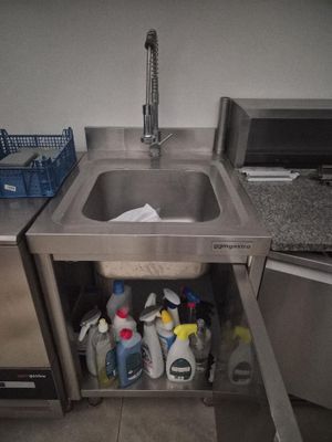 a stainless steel sink in the corner of a kitchen