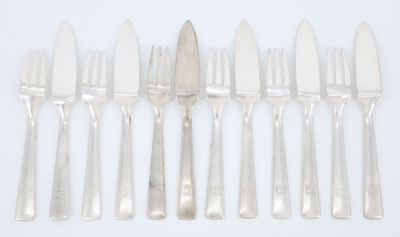 six couteaux argentés et six couteaux sur une surface blanche