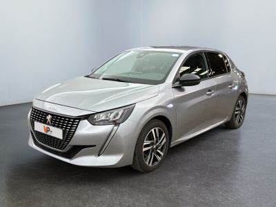 Une voiture argentée est garée dans une pièce au sol noir.
