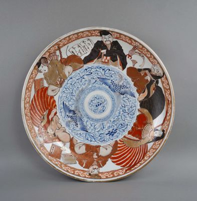 une assiette bleue et blanche avec une photo de personnes dessus