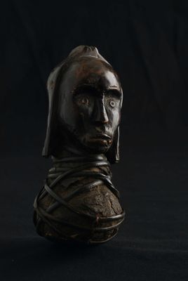 statue d'un homme portant une capuche, sur fond noir