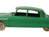 une petite voiture verte posée sur une surface blanche