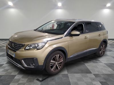 Le SUV doré est garé sur un sol en carrelage à damier.