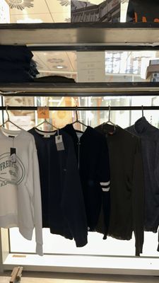 a lot of shirts hanging on a rack in a store