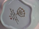 a close up of a white vase with a gold design on it