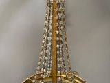 brass plated chandelier with glass leaves and crystals hanging from the ceiling