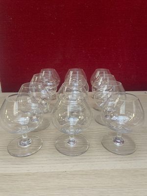 six empty wine glasses sitting on a table with a red background