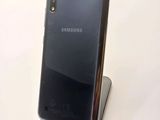 the back of a black samsung phone sitting on top of a metal stand