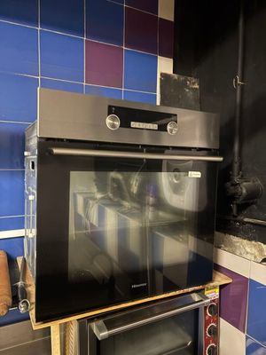 two ovens in a kitchen with blue tiles on the wall