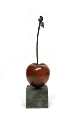 sculpture of an apple on a block with a leaf sticking out of it