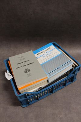 de nombreux livres dans une caisse bleue posée sur la table