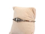 an image of a small pillow with a silver bracelet on it