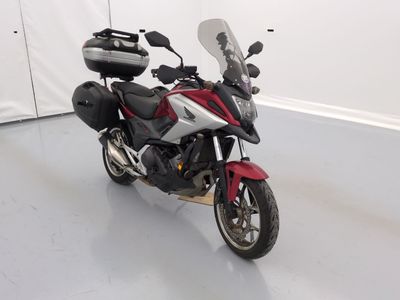 une moto rouge et blanche garée dans une pièce blanche