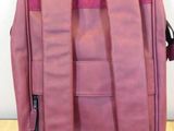 purple leather backpack with zippers on top of it on a wooden floor