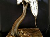 a bronze sculpture of a tree with a bird on it